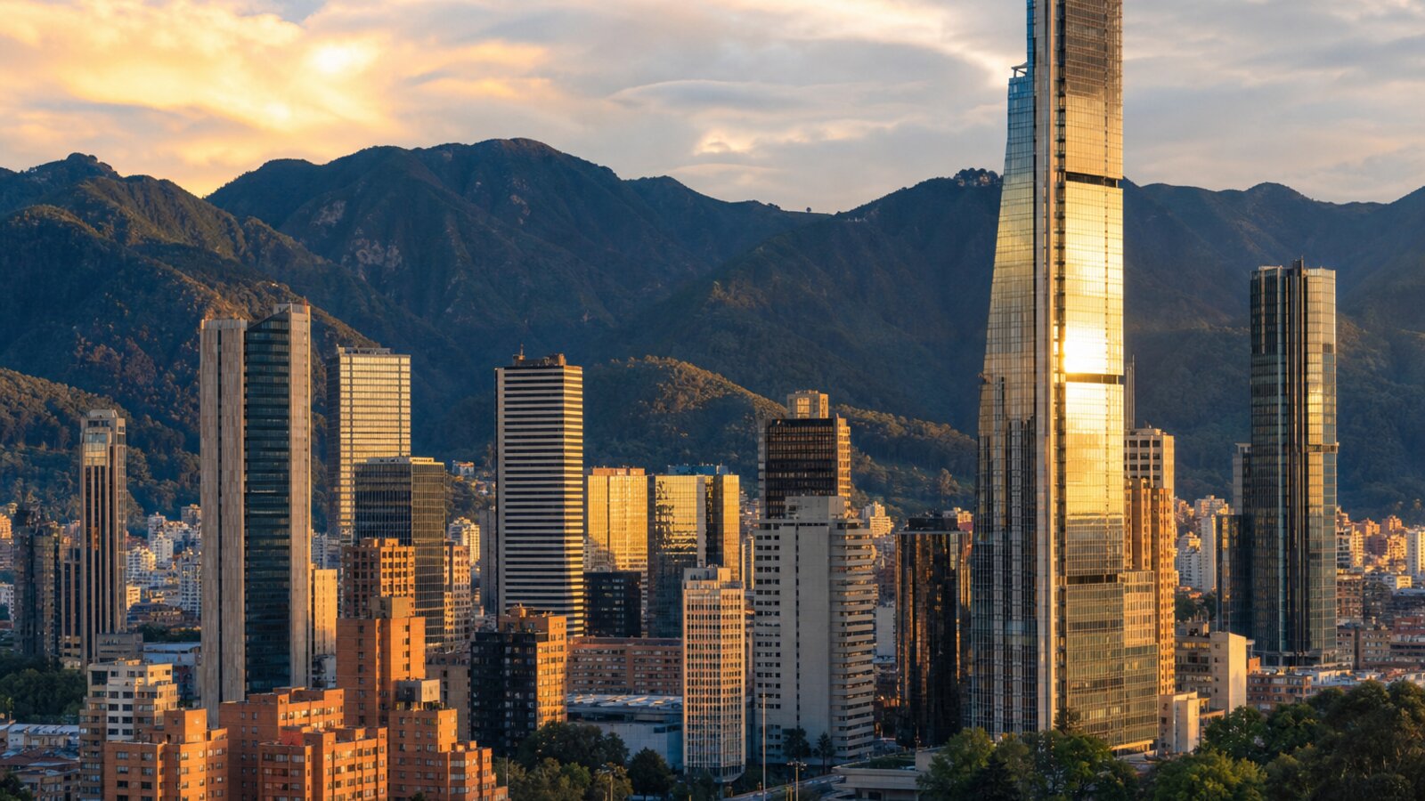 Skyline contemporáneo de Bogotá al atardecer con torres de cristal y los Andes al fondo